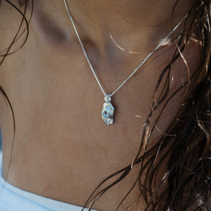 Pendente Deriva in argento 925 con topazio azzurro indossato su catena veneziana, close-up décolleté — GCenterprise